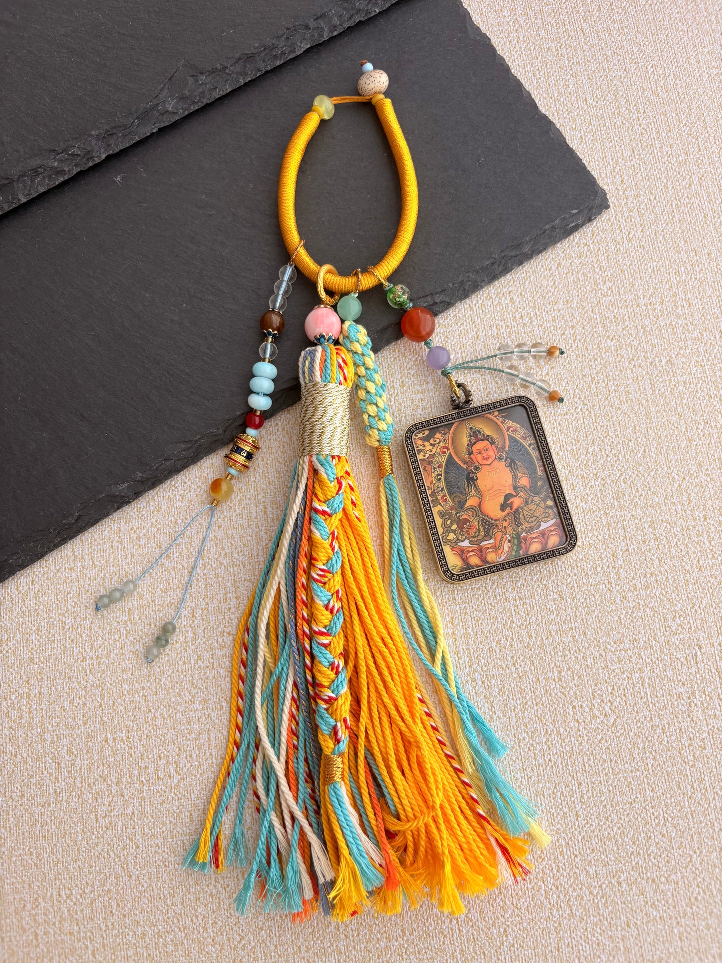 Yellow Jambhala Thangka Charm with Prayer Wheel Tassel in Tibetan Golden Yellow